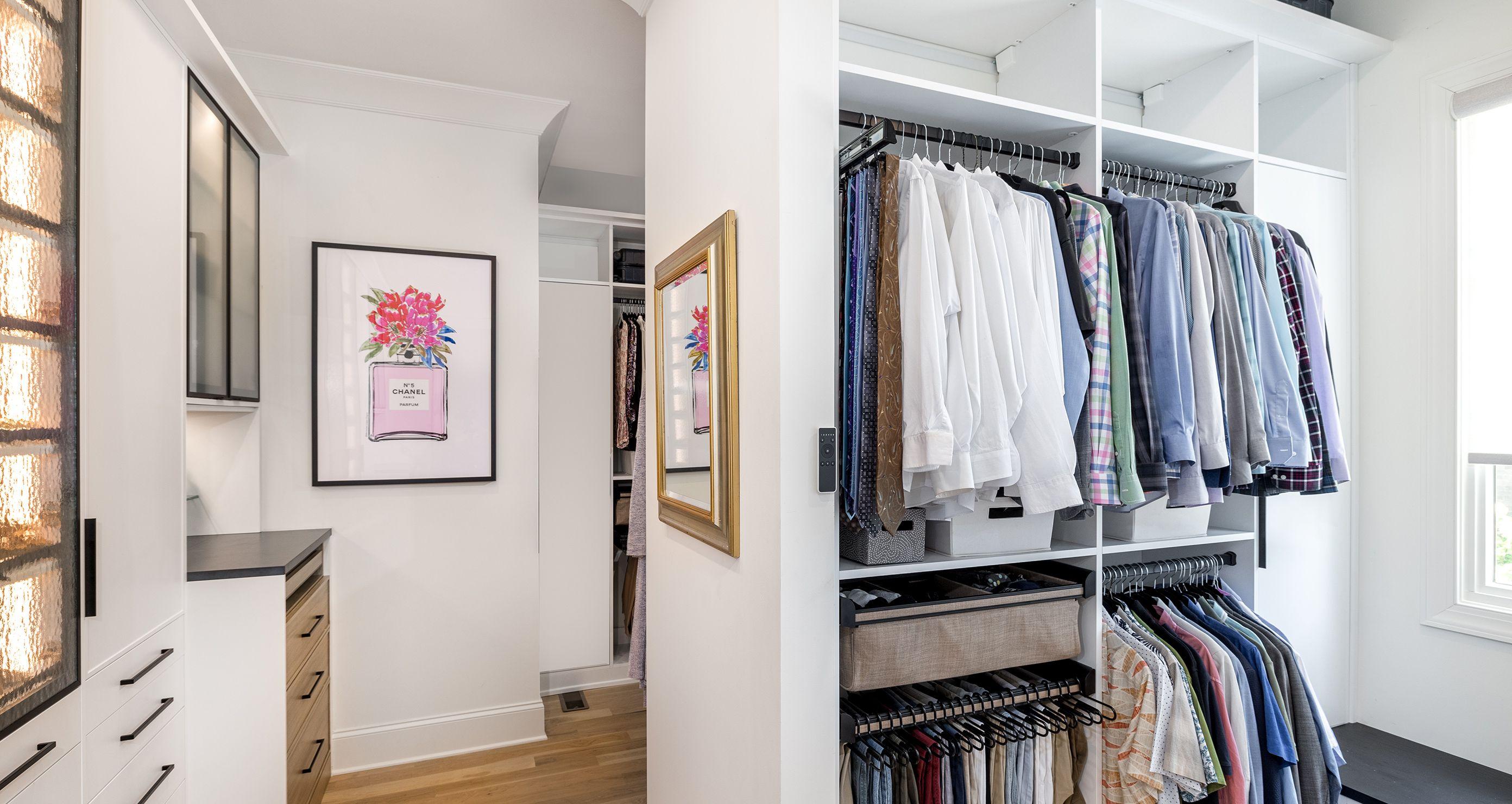 Master his closet is designed in a white wood grain finish with custom shelving and drawers created by California Closets