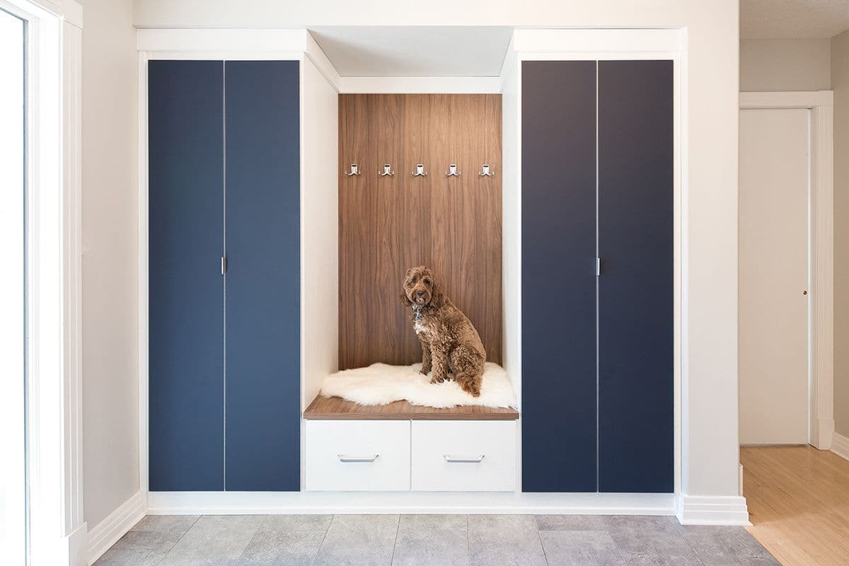 Custom entrway closet storage with bench doubling as pet bed with storage drawers by California Closets. Activate to enhance image.