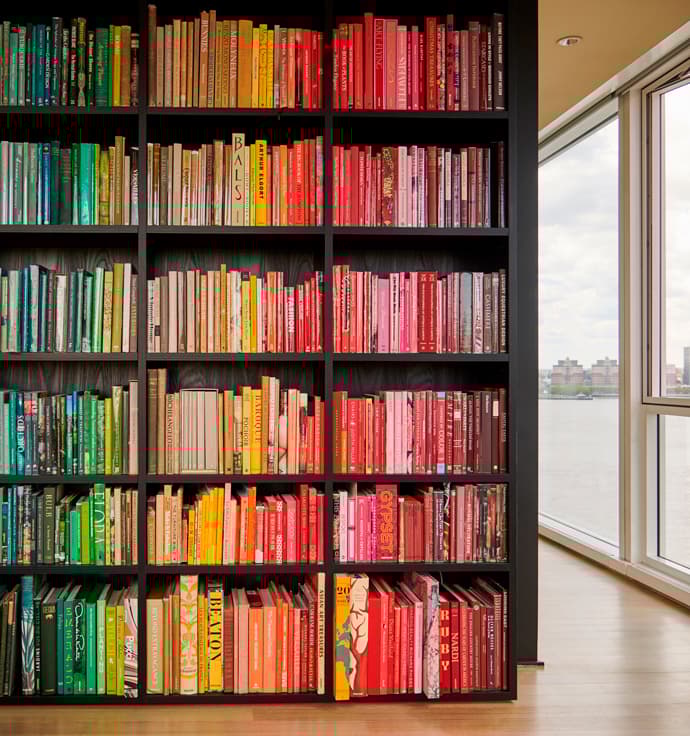 Custom bookshelves from floor to ceiling designs in dark wood grain finish by California Closets