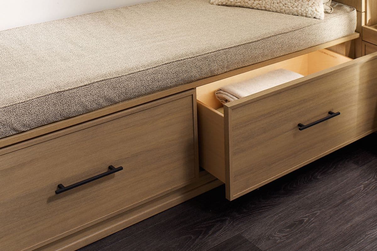 Iluminación LED en cajones extraíbles debajo de un banco de ventana en un vestidor de California Closets