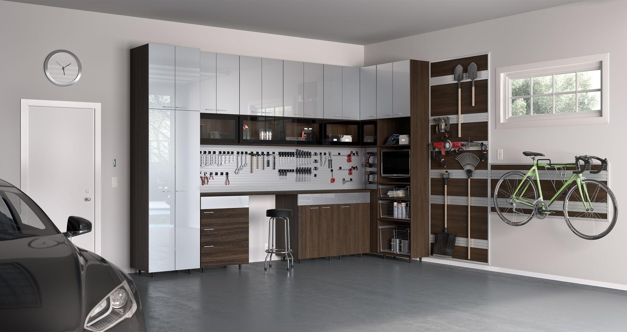 Banco de trabajo rodeado de gabinetes de almacenamiento de garaje con acabado oscuro de California Closets