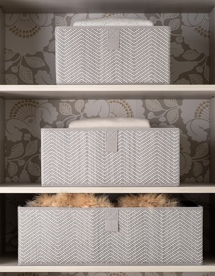 Closet shelf organization accessories and fabric storage baskets by California Closets showcasing a custom decorative back panel design.
