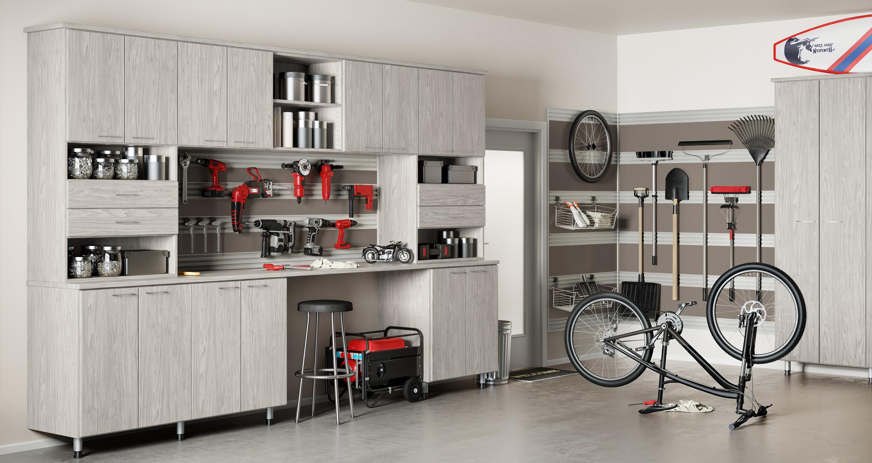Light finish garage storage cabinets and countertop space for tools by California Closets