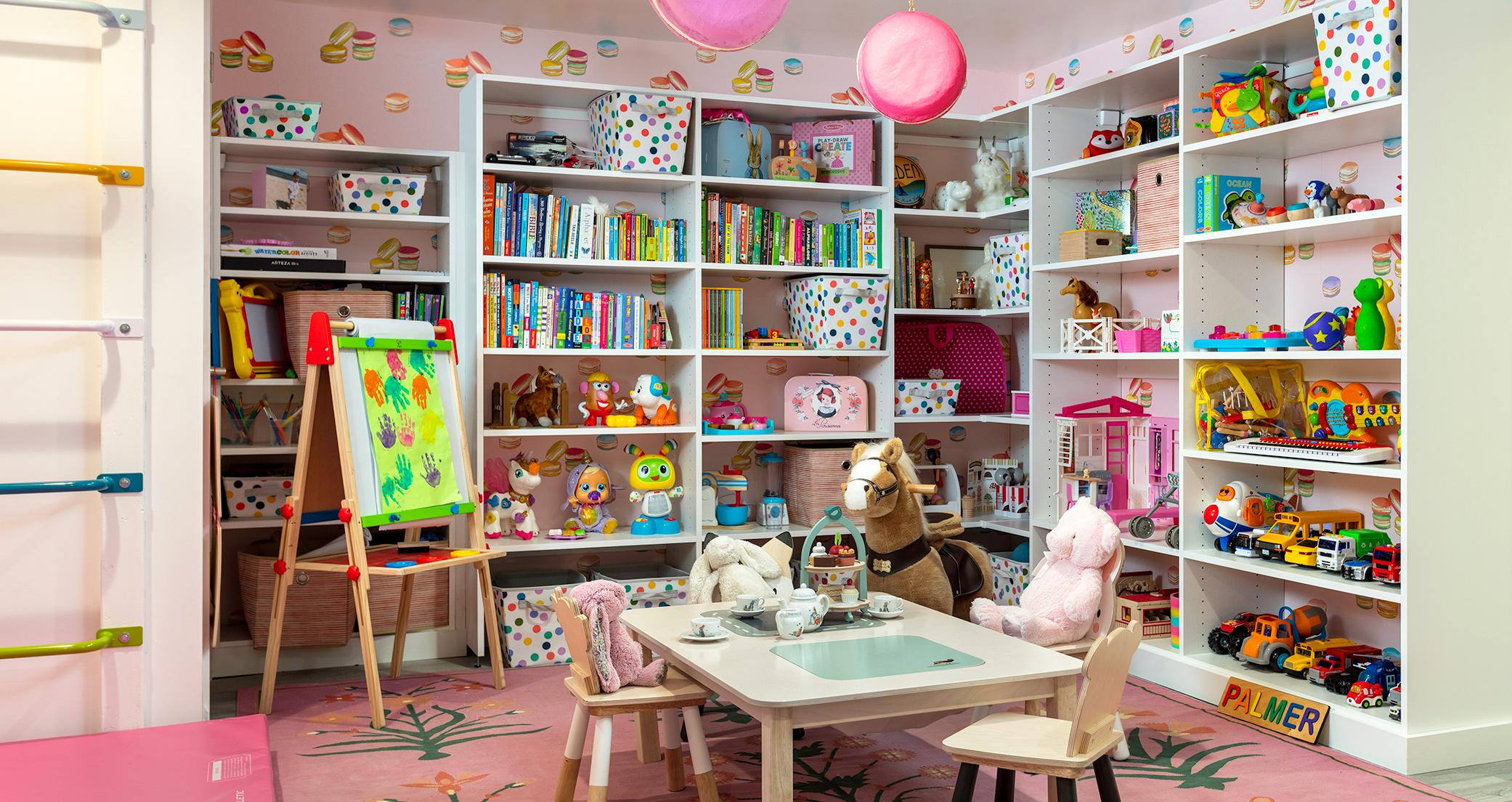 Sala de juegos con estanterías personalizadas, mesa para fiestas del té, estudio de artista y almacenamiento personalizado de California Closets