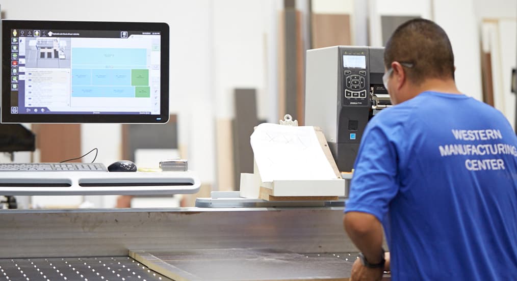 Worker operating energy-efficient CNC machinery at a California Closets manufacturing facility