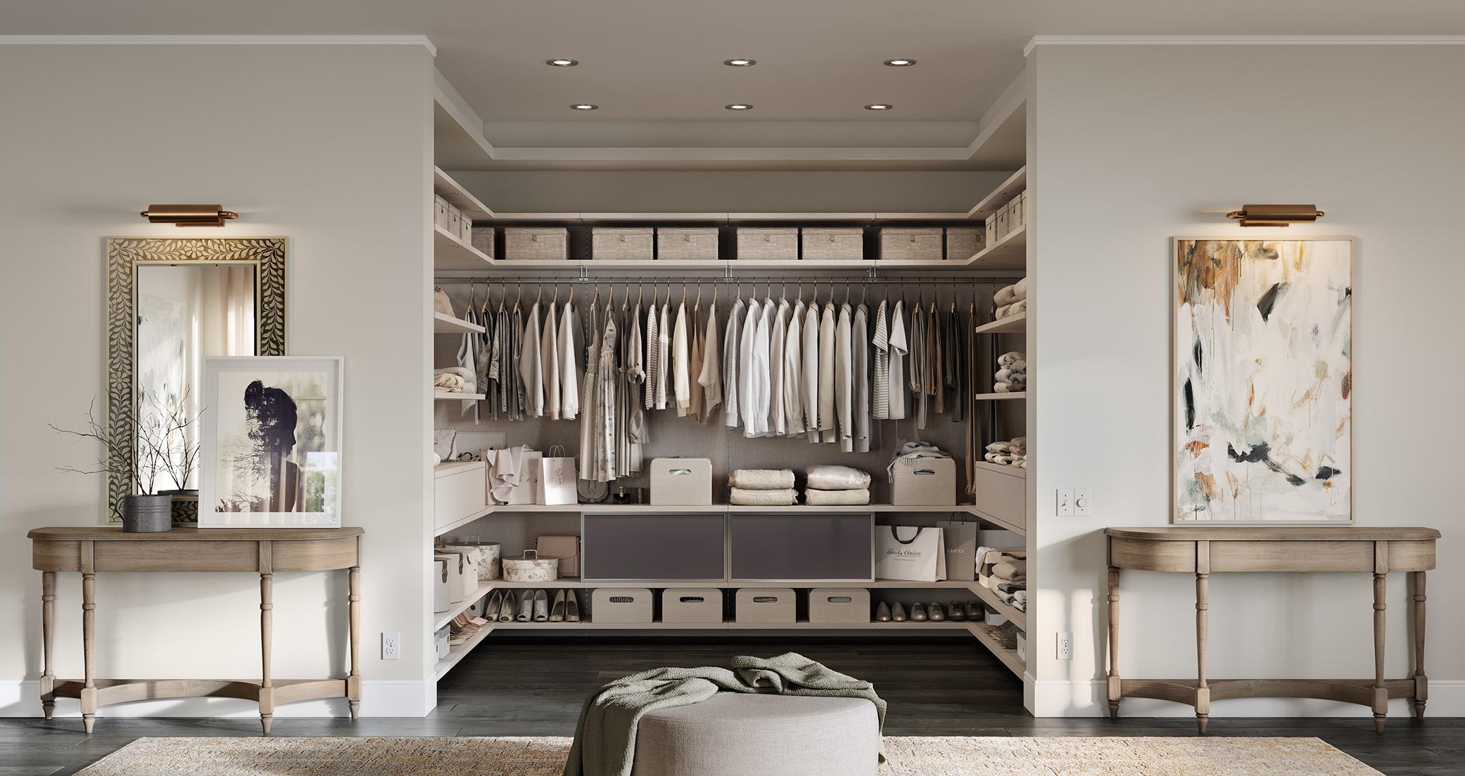 A u-shaped walk in closet design with floating shelves and hanging rods in light wood grain finish by California Closets
