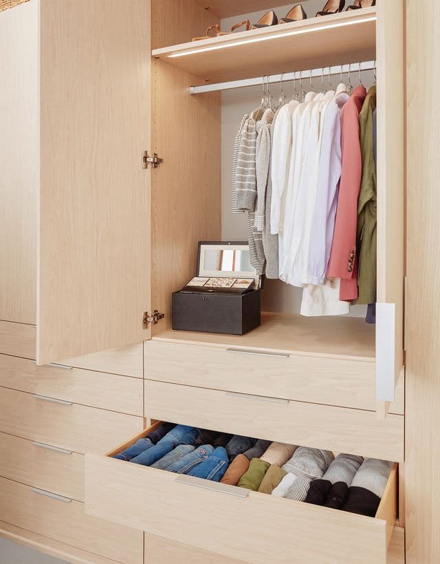 Wardrobe closet with custom doors, cabinets and drawers and shoe storage created by California Closets