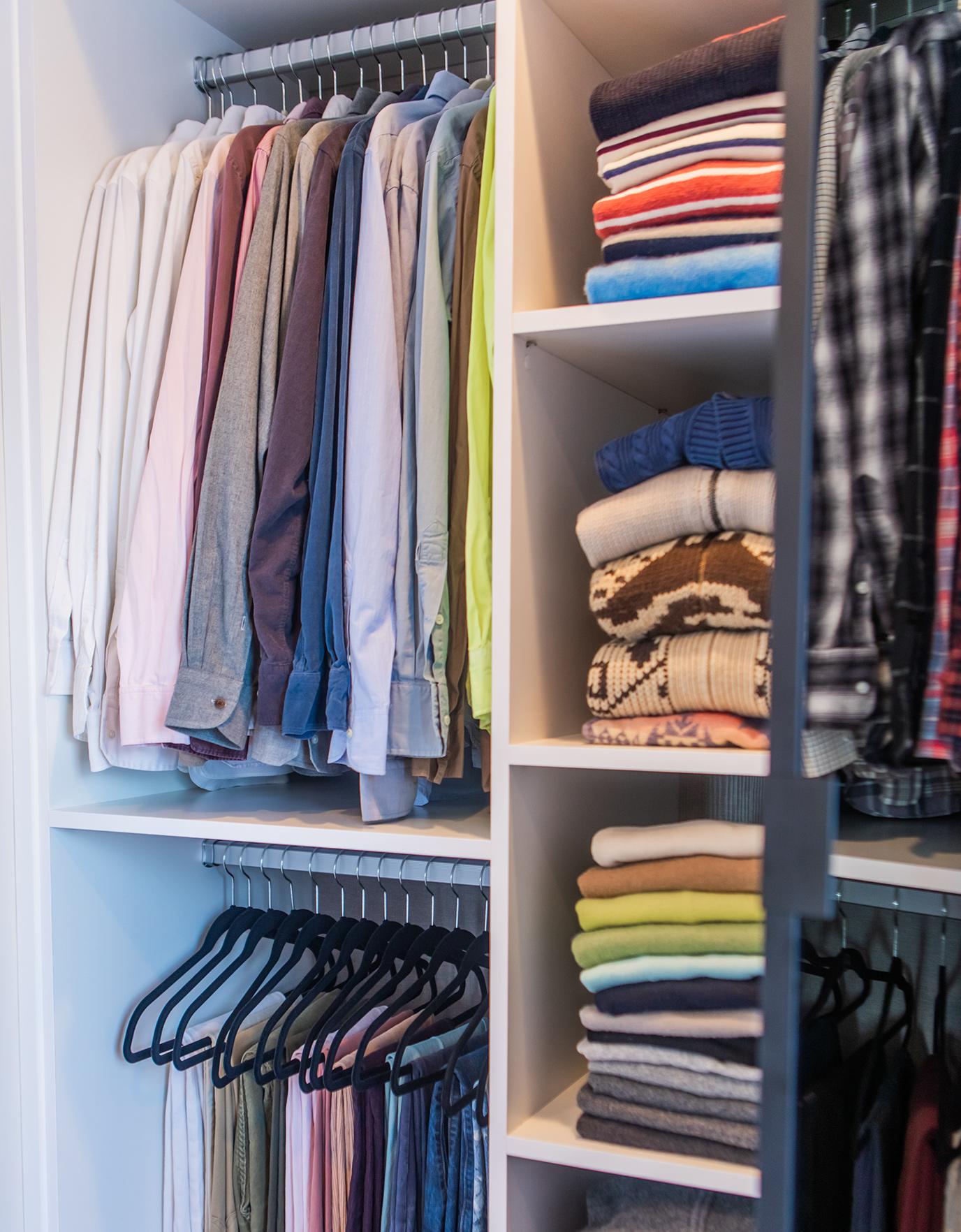 Armario organizado con estantes abiertos y postes y varillas de armario de California Closets