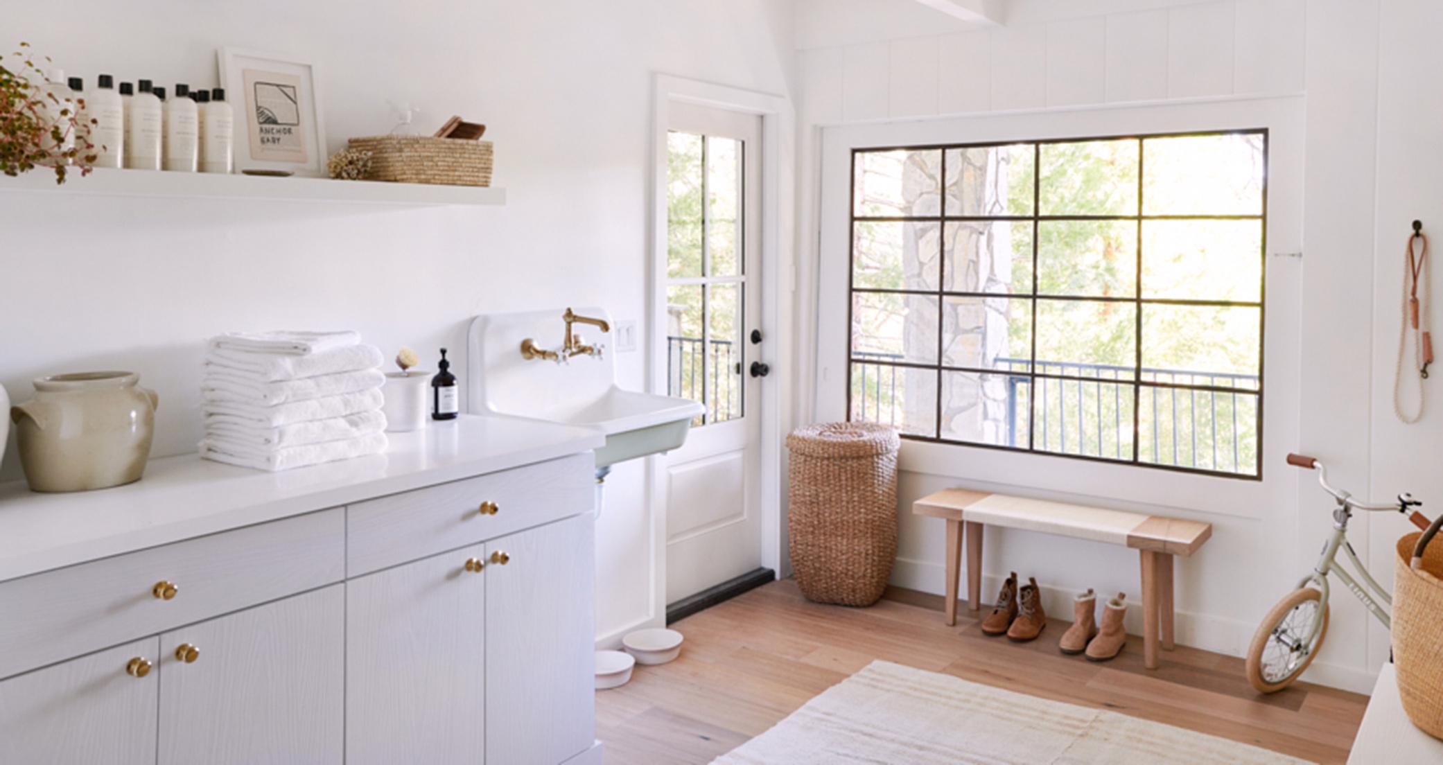 Amplio vestíbulo con gabinetes de almacenamiento, encimeras y estanterías creado por California Closets