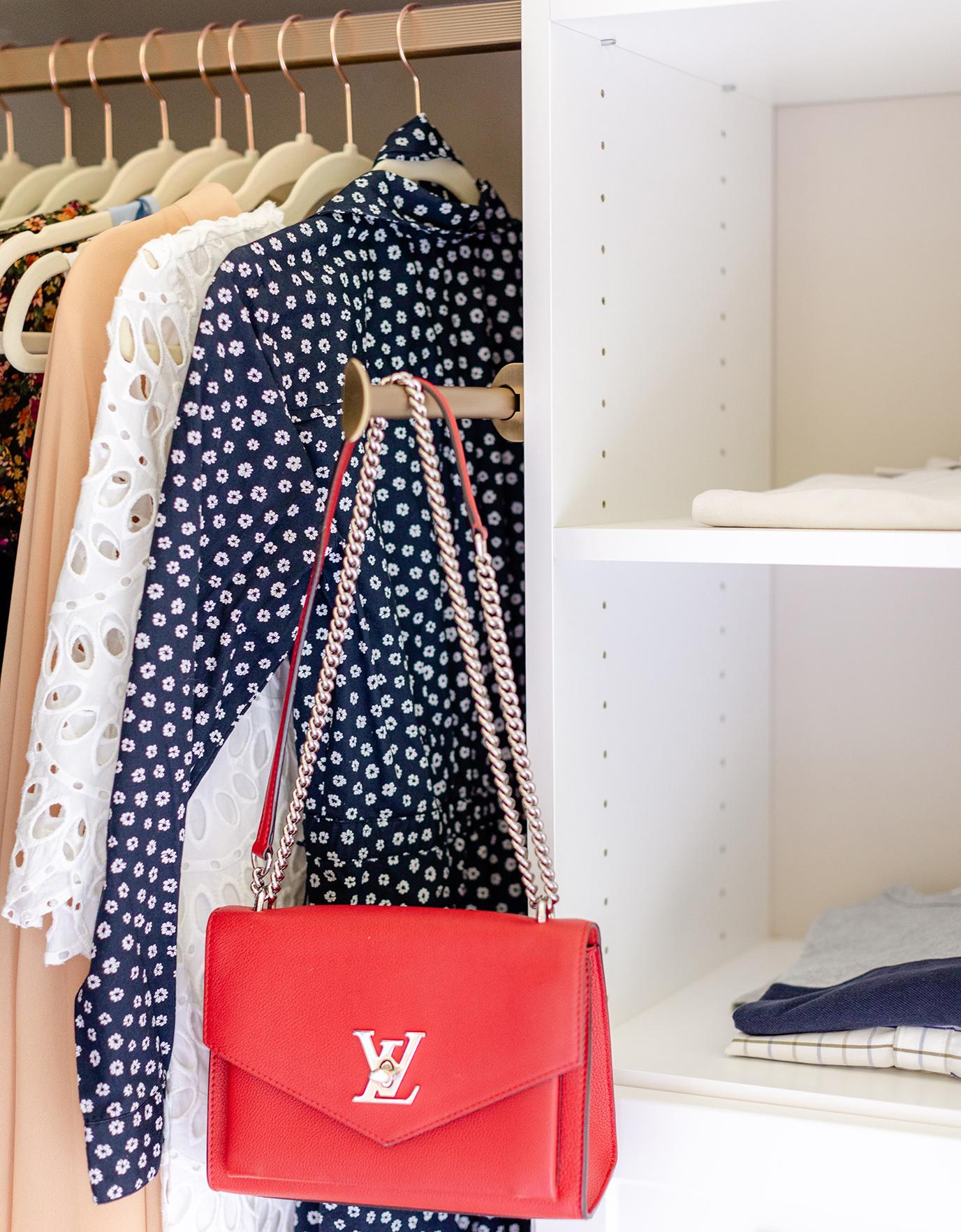 Close up detail in walk in closet with garment rack being used for handbag created by California Closets
