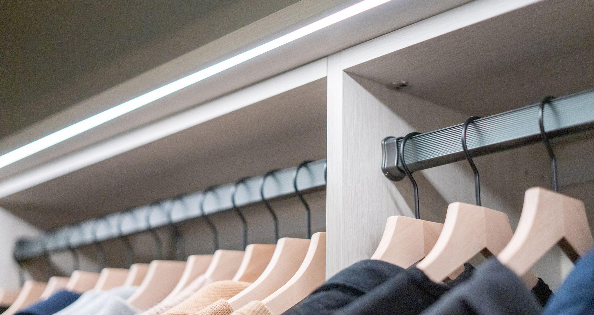 Racks de ropa de armario utilizando iluminación LED de cinta creada por California Closets