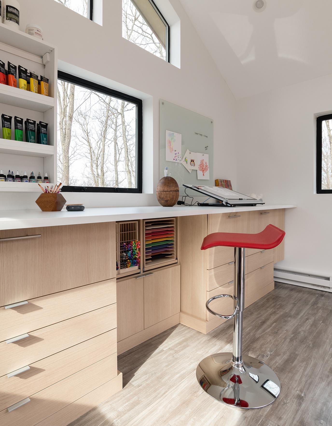 Diseño de estudio para un artista artesanal con estanterías, cajones y escritorio personalizados de California Closets