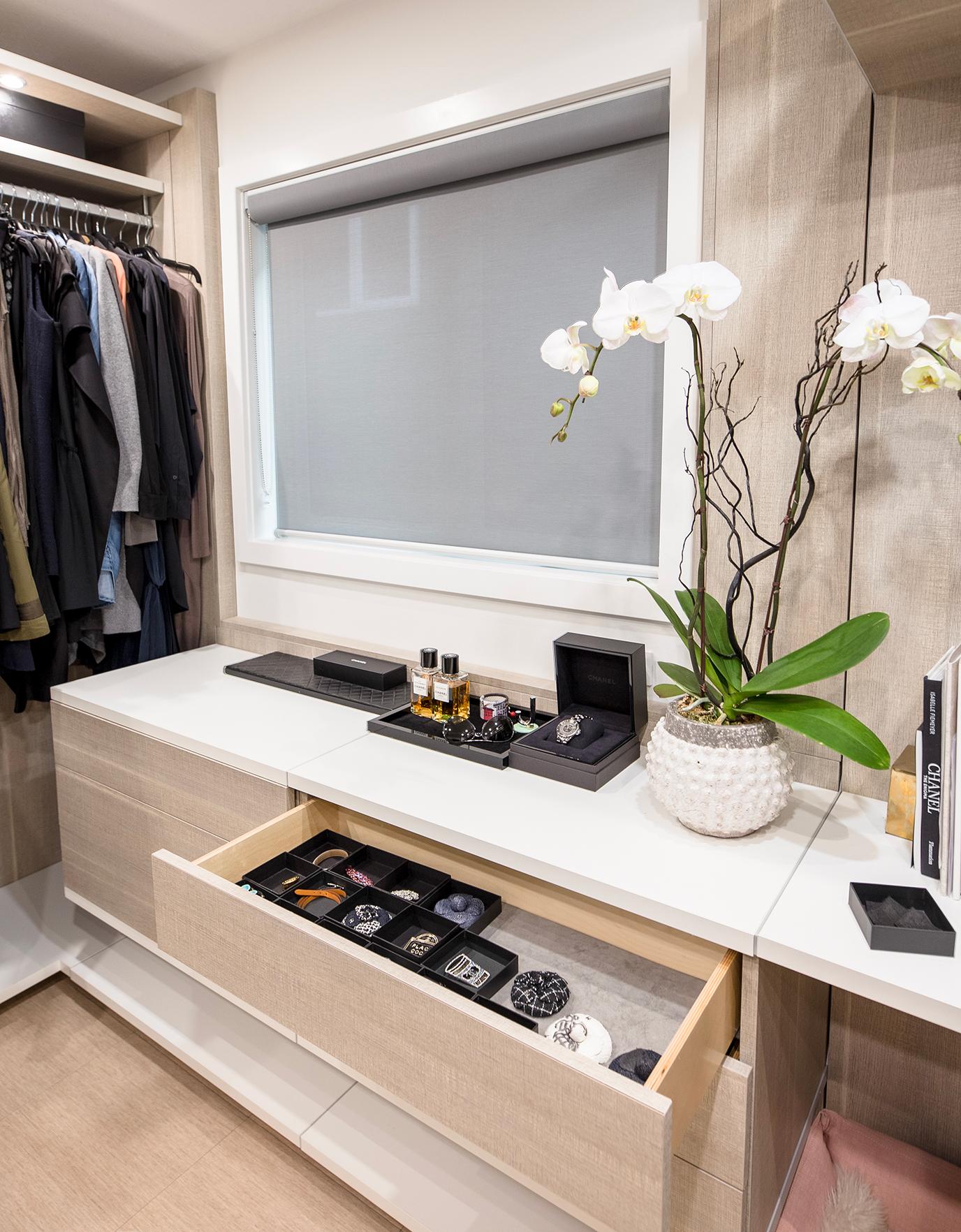 Vestidor diseñado con almacenamiento flotante para accesorios y ropa interior por California Closets