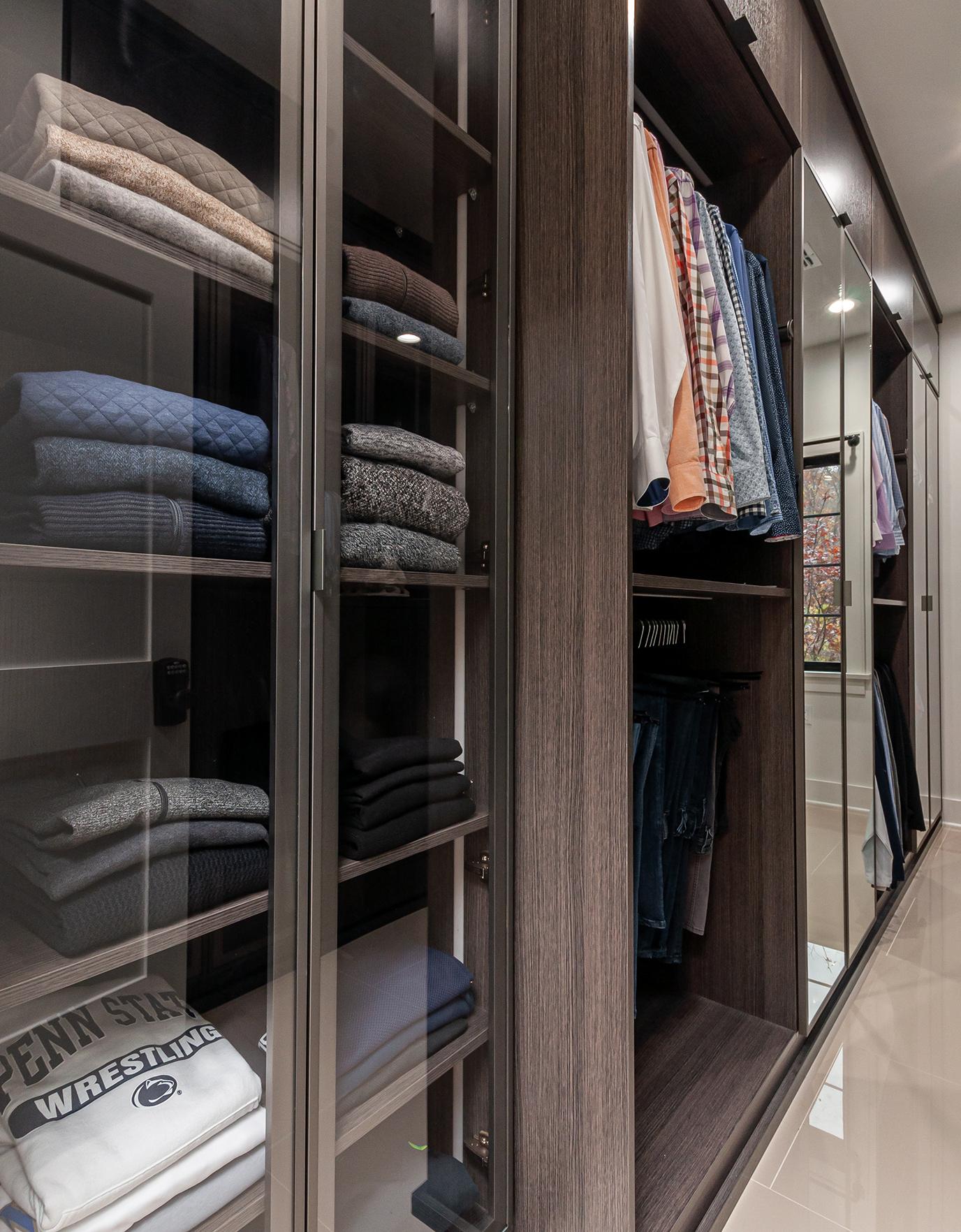 Vestidor diseñado para el guardarropa de un hombre con puertas con espejo y estantes abiertos de California Closets