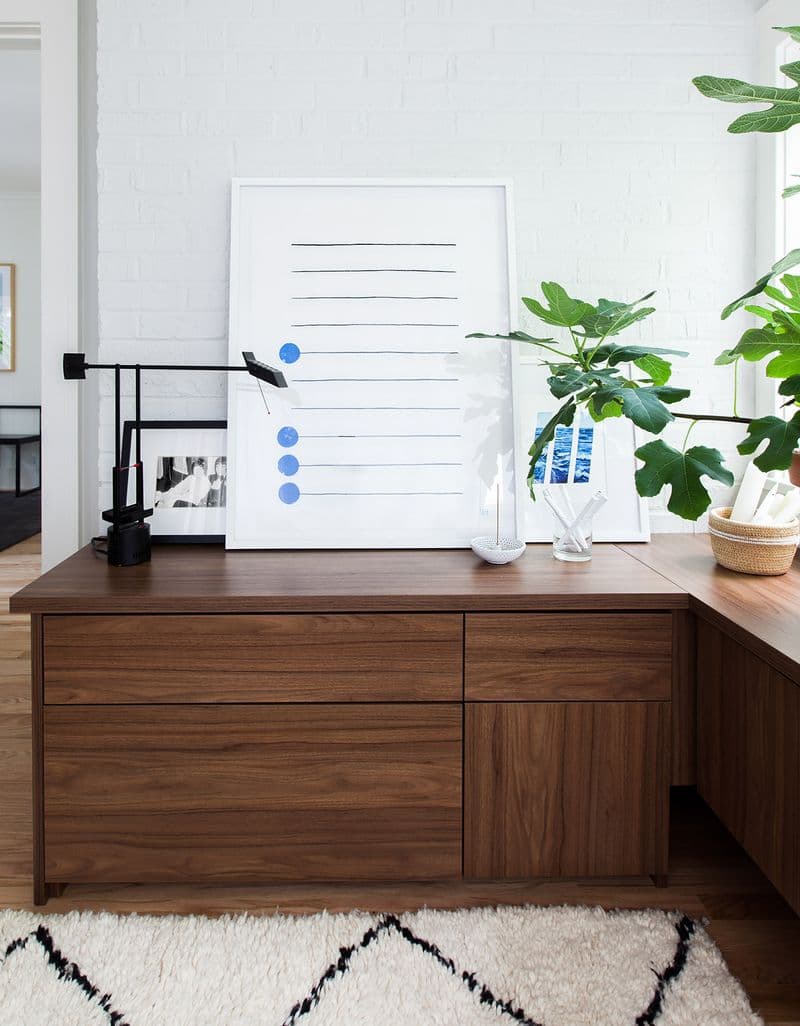 Espacio de trabajo diseñado con gabinetes flotantes de madera oscura por California Closets