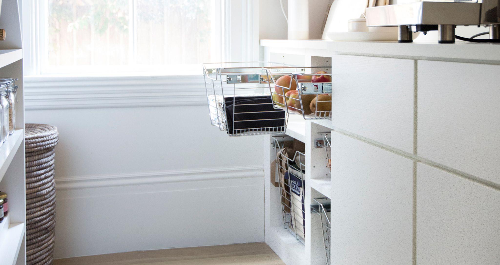 Wire basket storage for kitchen pantry next to open shelving and custom cabinets by California Closets