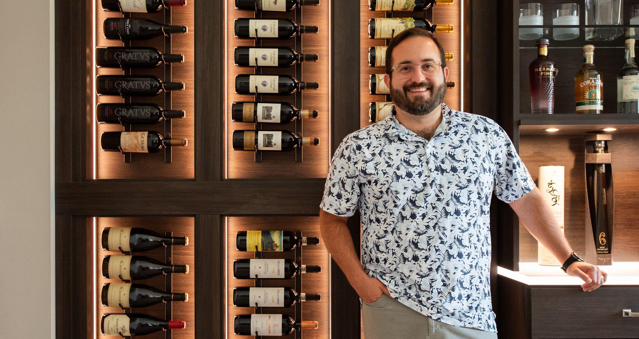 Vinoteca doméstica diseñada con luces LED, estantes de cristal y botelleros por California Closets