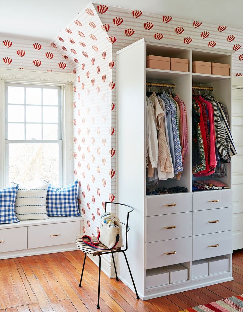 Clare Vivier's walk in closet with a window storage bench and built in wardrobe created by California Closets