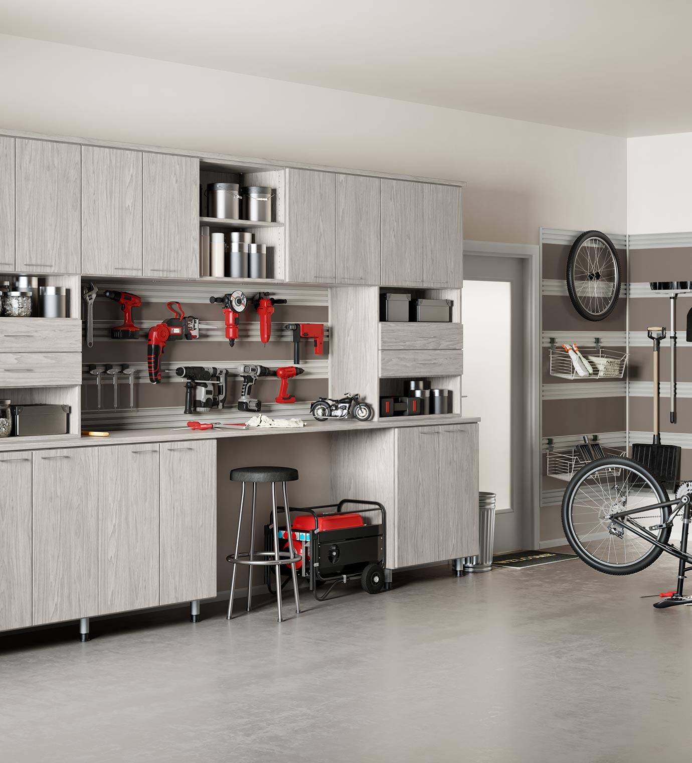 Sistema personalizado de almacenamiento en gabinetes para garaje con rieles fusionados y banco de trabajo creado por California Closets
