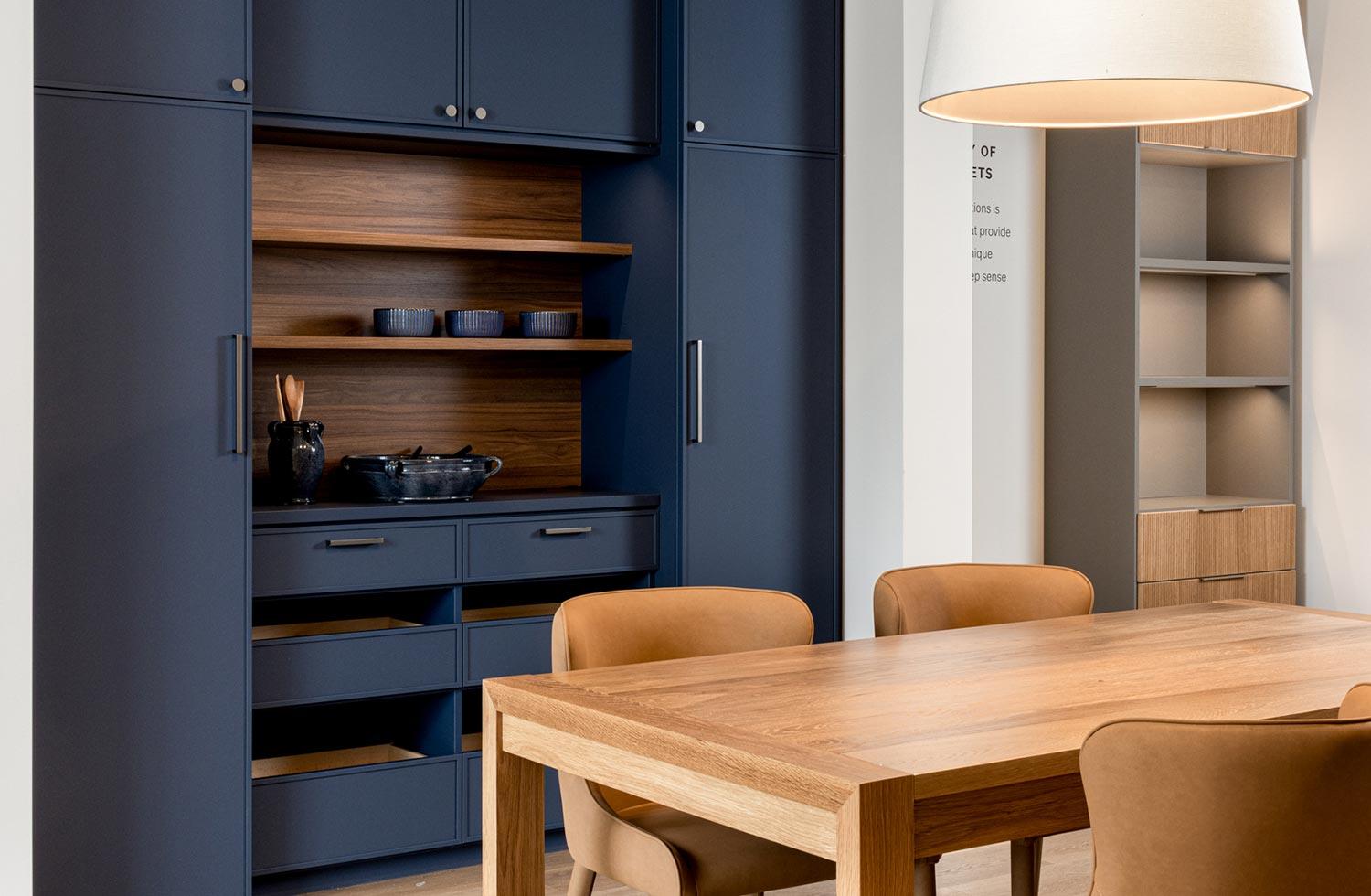 Custom built storage shelving in a dark blue wood finish from California Closets