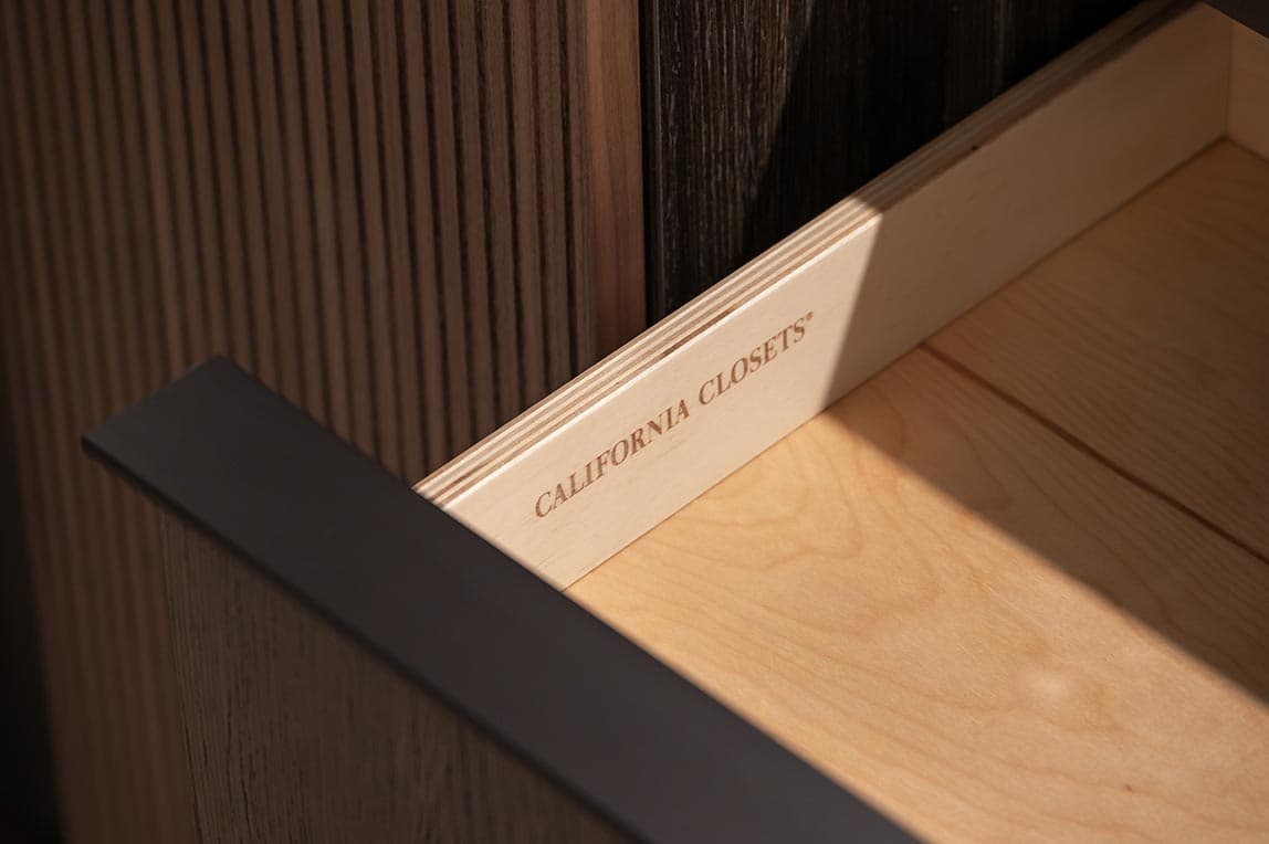 Acabado en madera oscura con cajones de gabinete con cierre suave California Closets