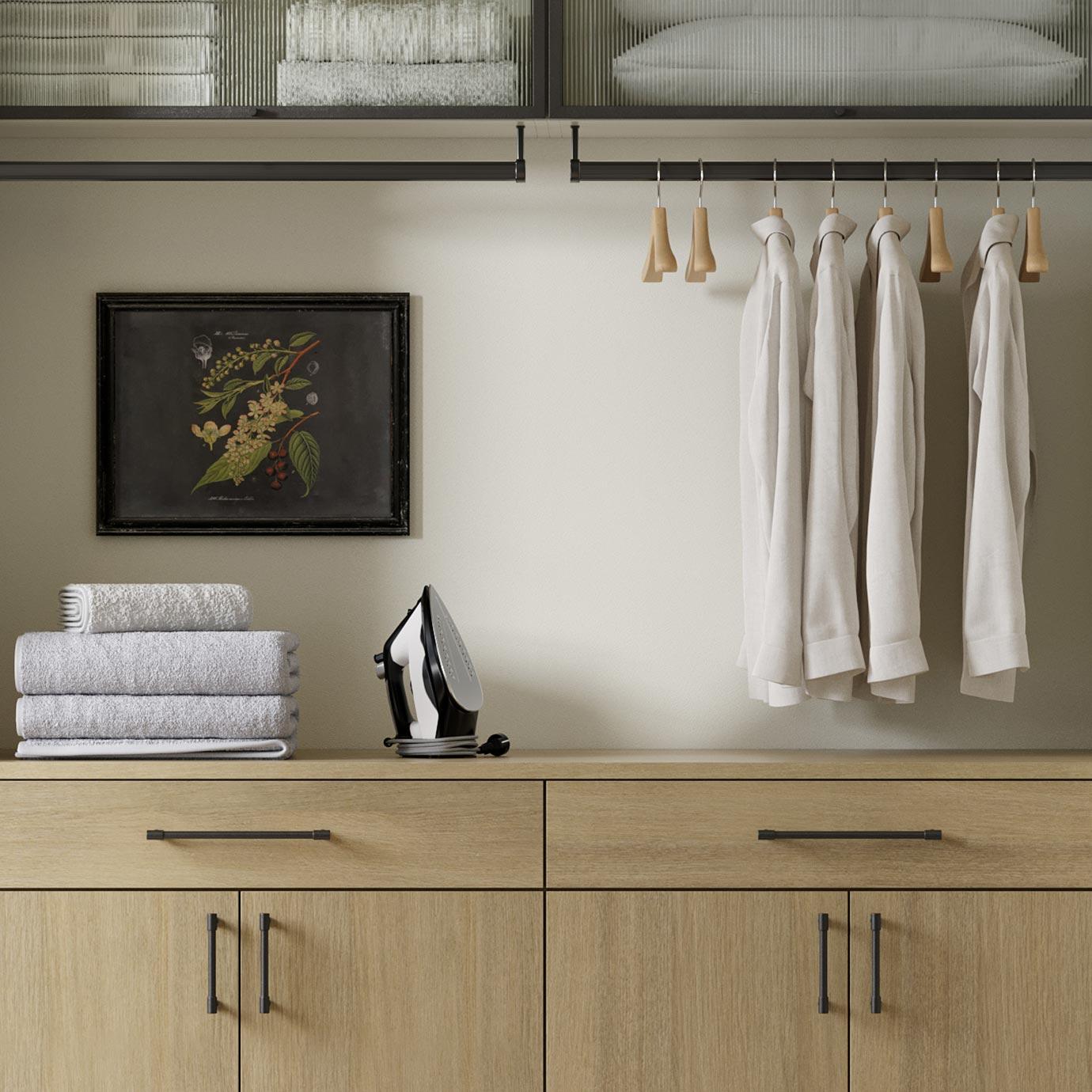 Small laundry room with cabinets and countertop folding area by California Closets