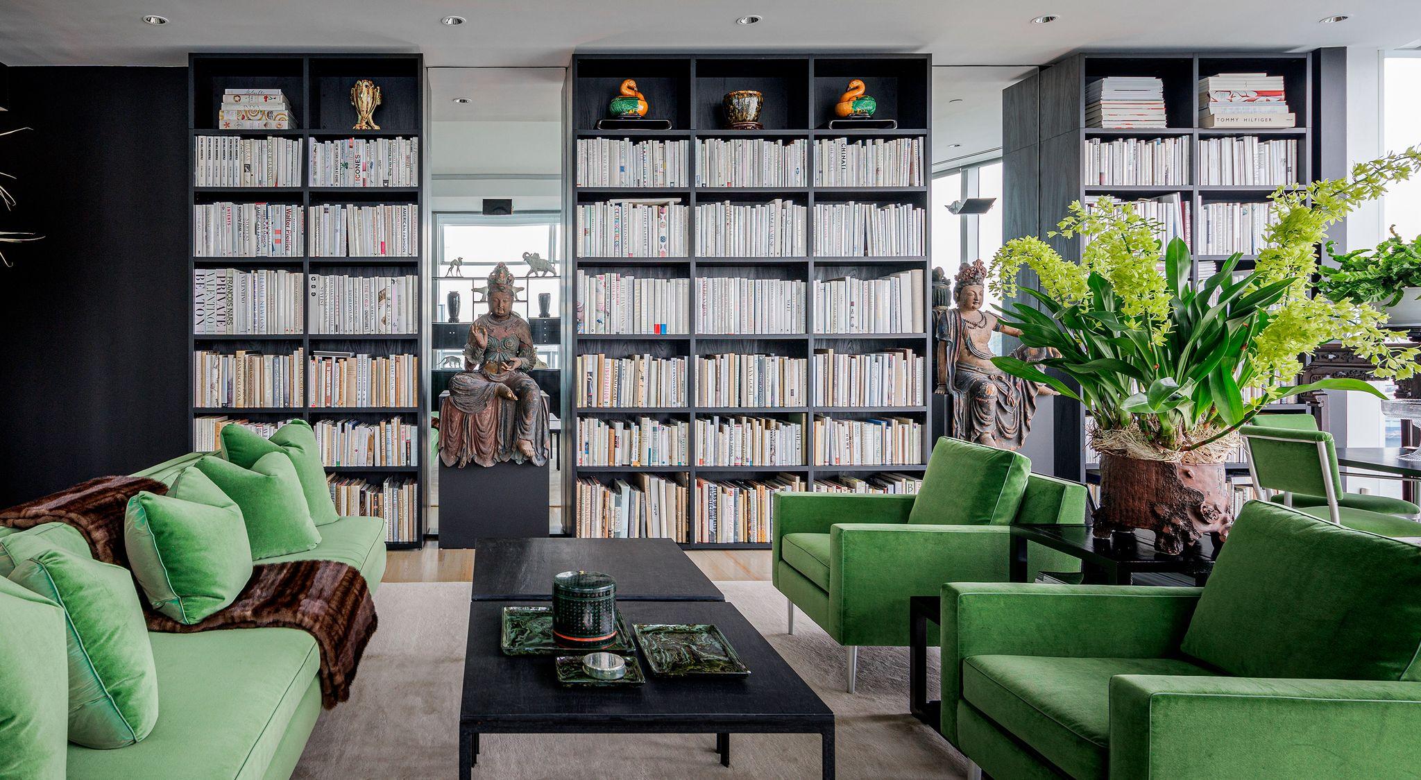 Librerías construidas con acabado de madera negra desde el suelo hasta el techo para la biblioteca doméstica de California Closets