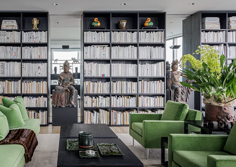 Bookshelves designed from floor to ceiling in dark wood finish for living space by California Closets