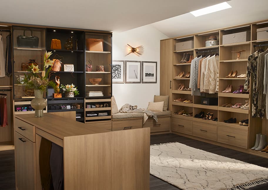 Natural finish cabinets, drawers, shelving in walk in layout created by California Closets