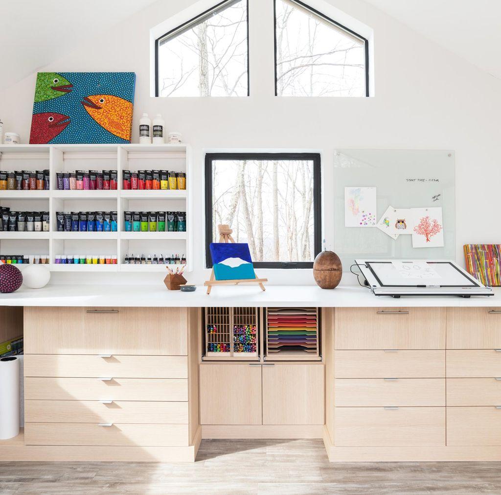 Crafting space with extra long countertops, custom cabinets and in light wood grain finish by California Closets