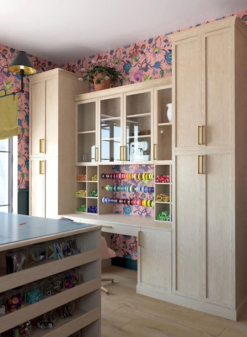 Custom designed craft room with cabinets, drawers and island desk space by California Closets