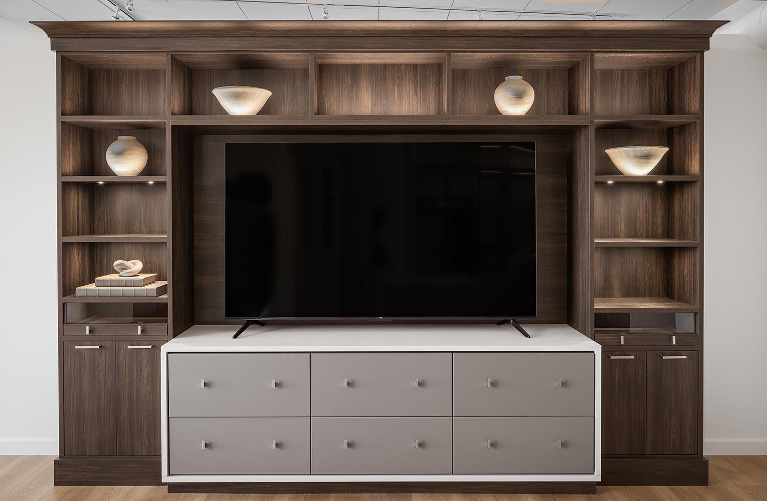 Custom home entertainment center wall storage with shelving and drawers in light and dark finishes by California Closets