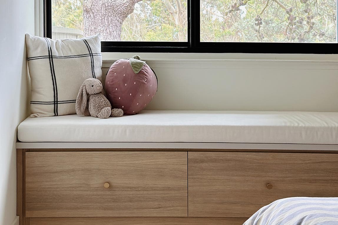 Asiento de ventana con banco de entrada personalizado con cajones debajo para espacio de almacenamiento por California Closets