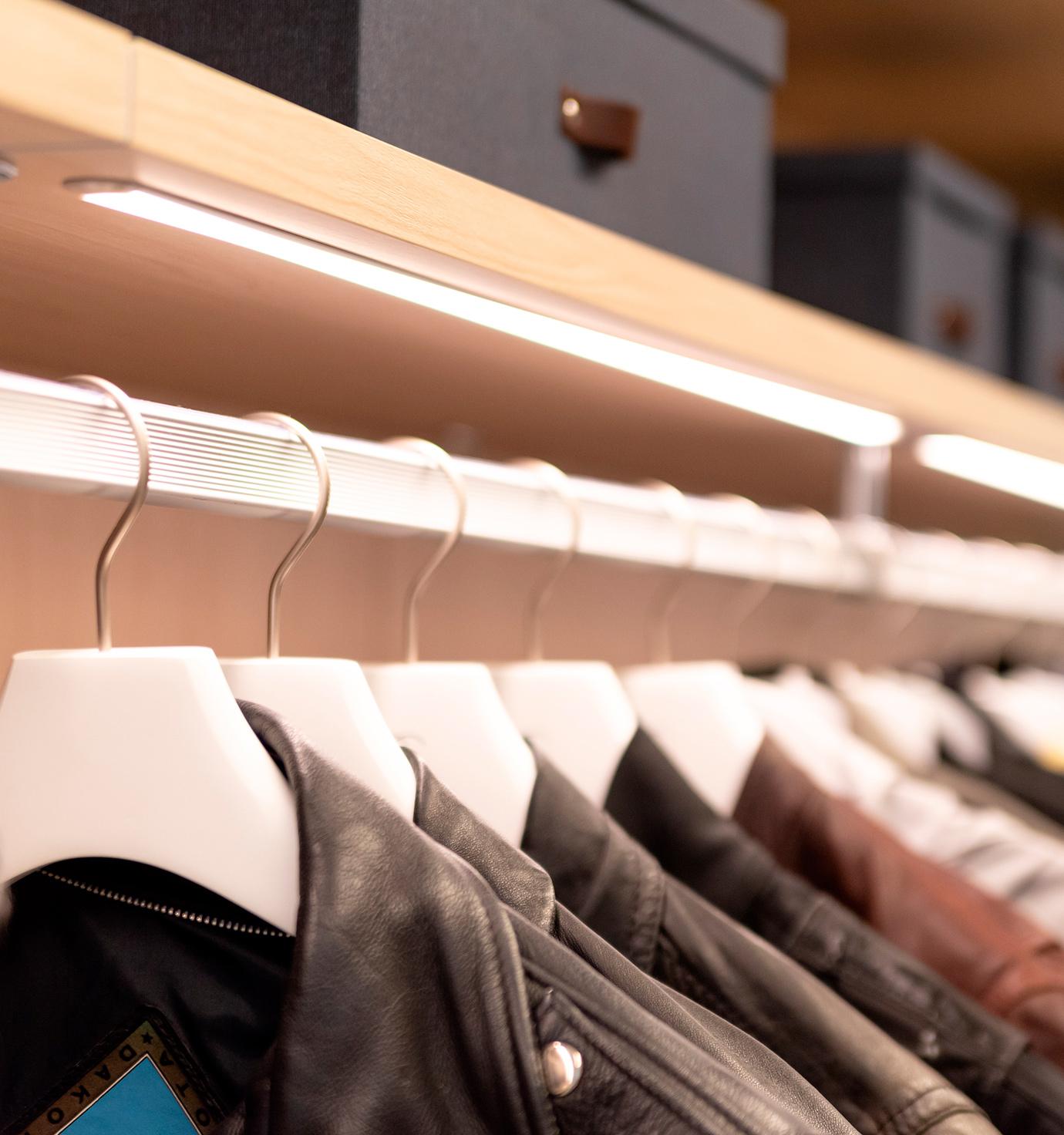 Accesorios de armario personalizados con iluminación LED sobre barras de ropa de California Closets