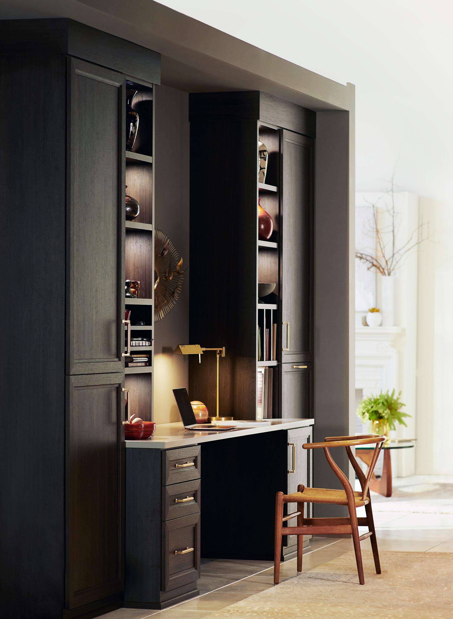 Custom home office with built in desk and cabinets in a dark wood finish by California Closets