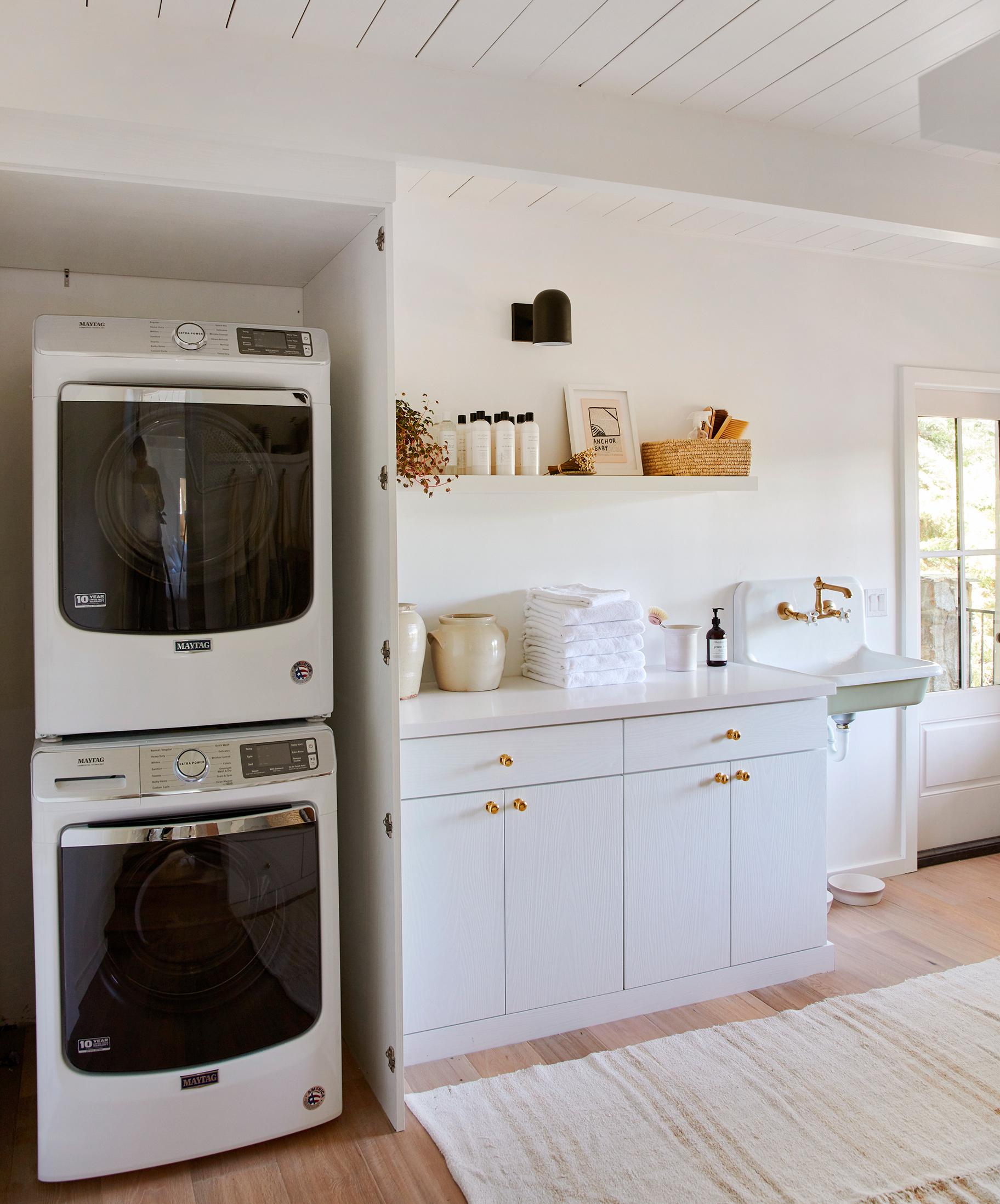 White laundry room ideas with countertop and hidden storage California Closets