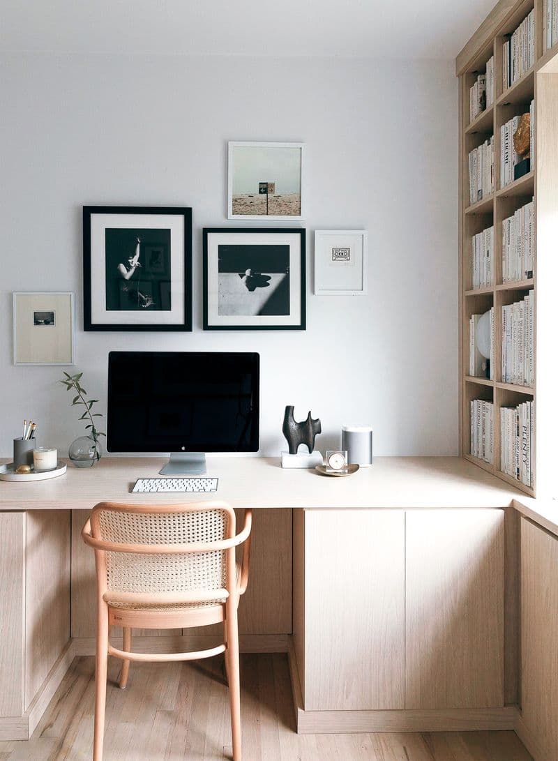 Natural wood finish home office design with built in desk and shelves by California Closets