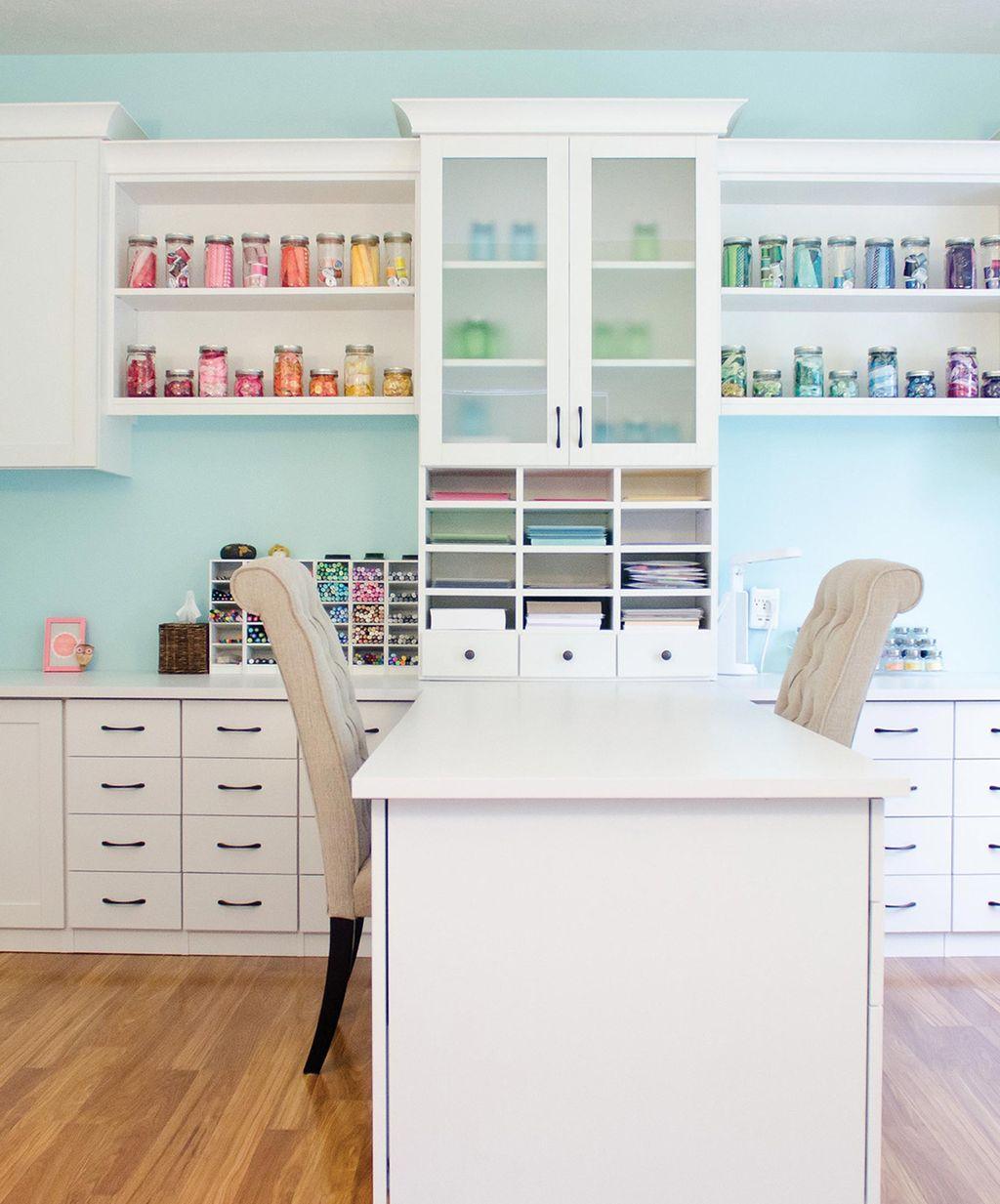 Gabinetes de almacenamiento en blanco mate, estanterías y diseño de cajones para una sala de manualidades por California Closets