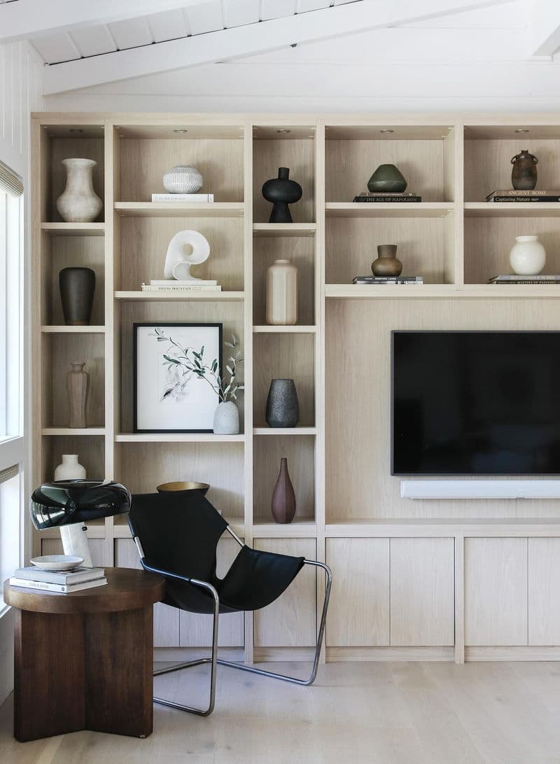 Custom-designed media center wall storage created for Anne Sage with open lighted shelving from California Closets