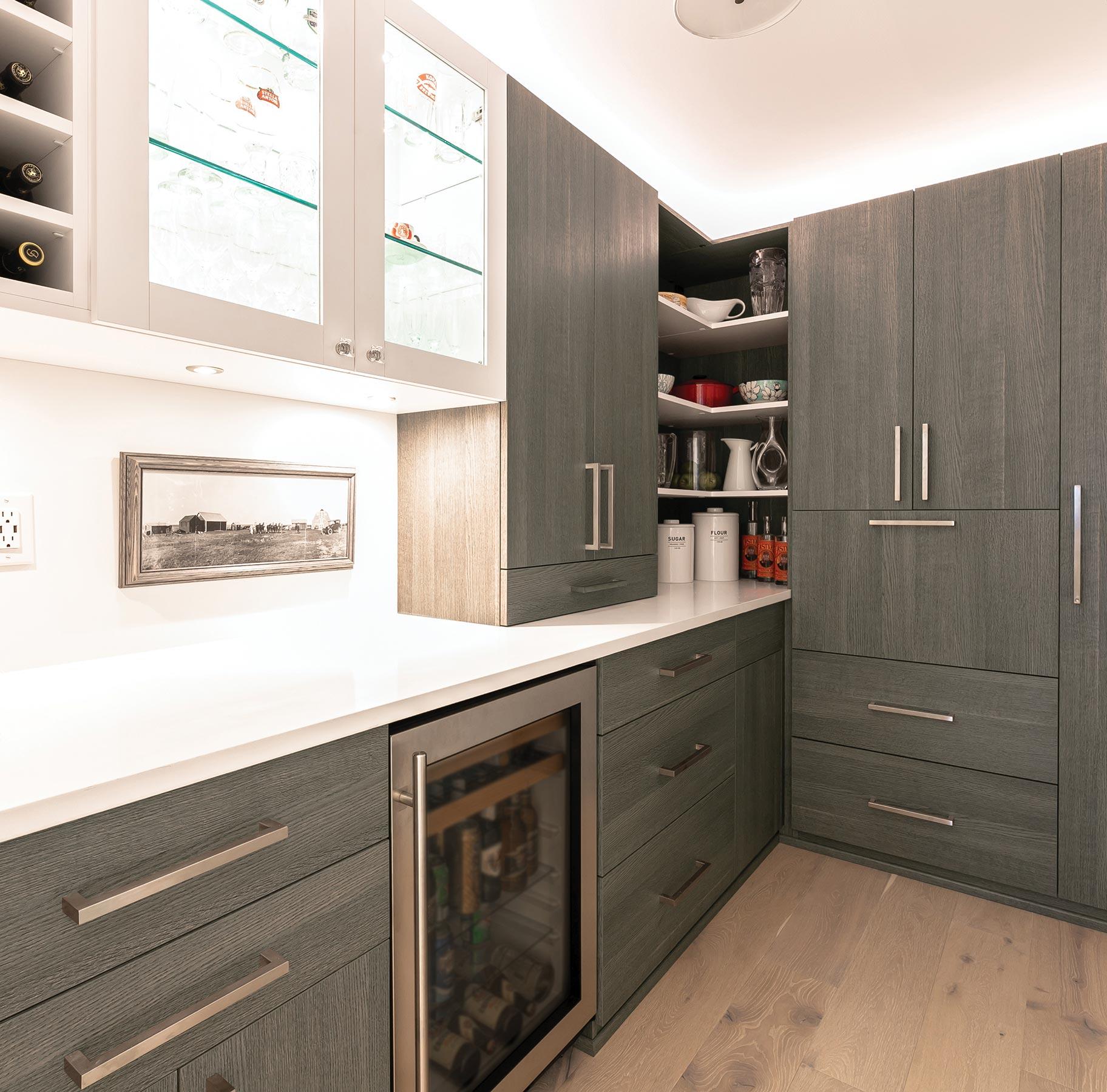 Organized kitchen pantry with wooden shelves and custom cabinets by California Closets