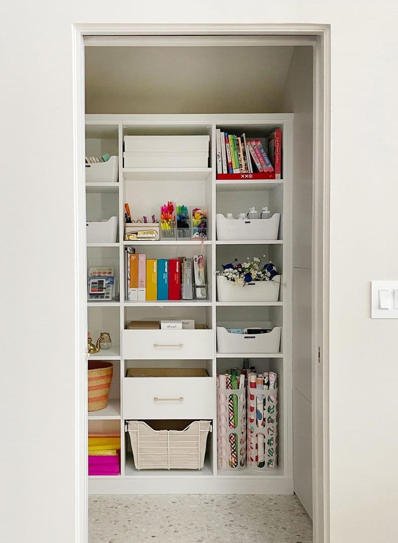 Espacio de arte y manualidades con gabinetes de almacenamiento y estanterías personalizadas por California Closets.