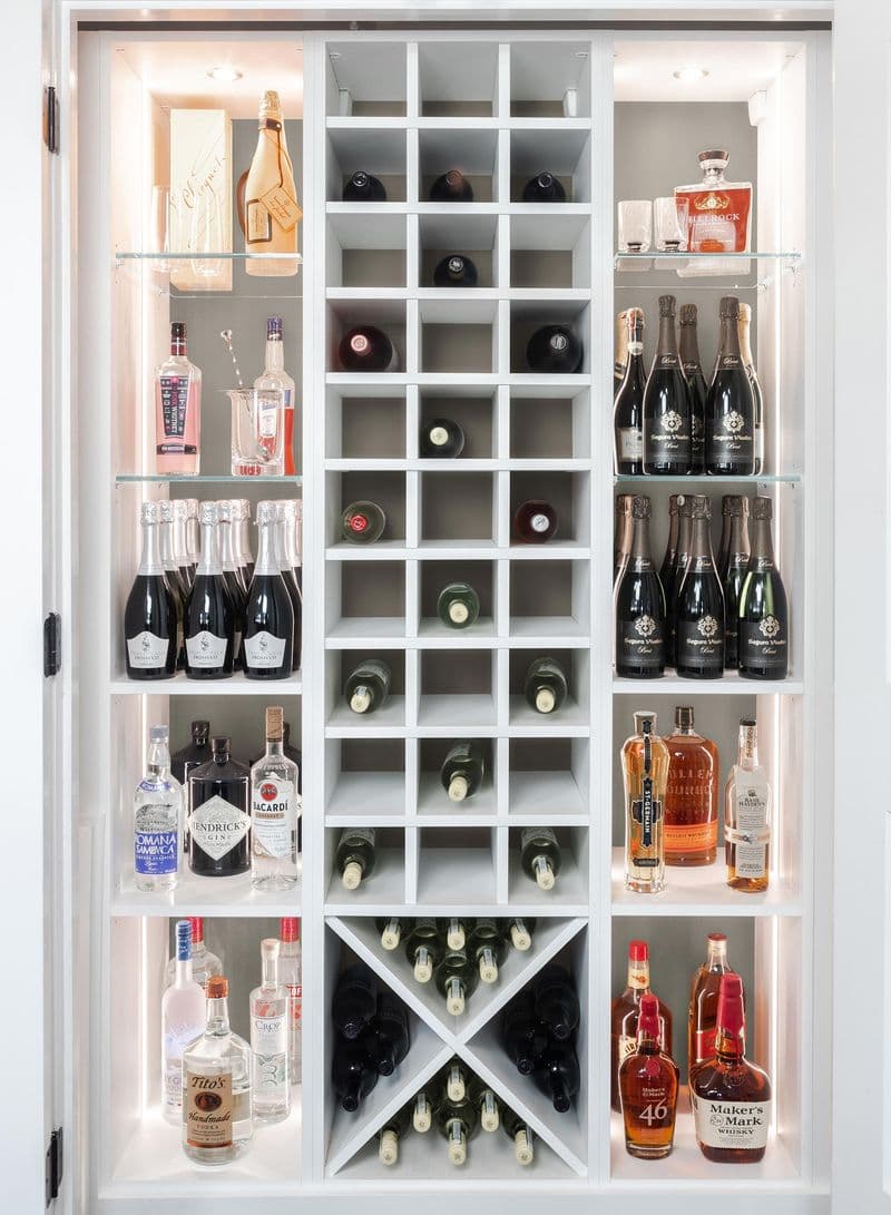 Estantería en X y iluminación personalizada para vinos en despensa por California Closets