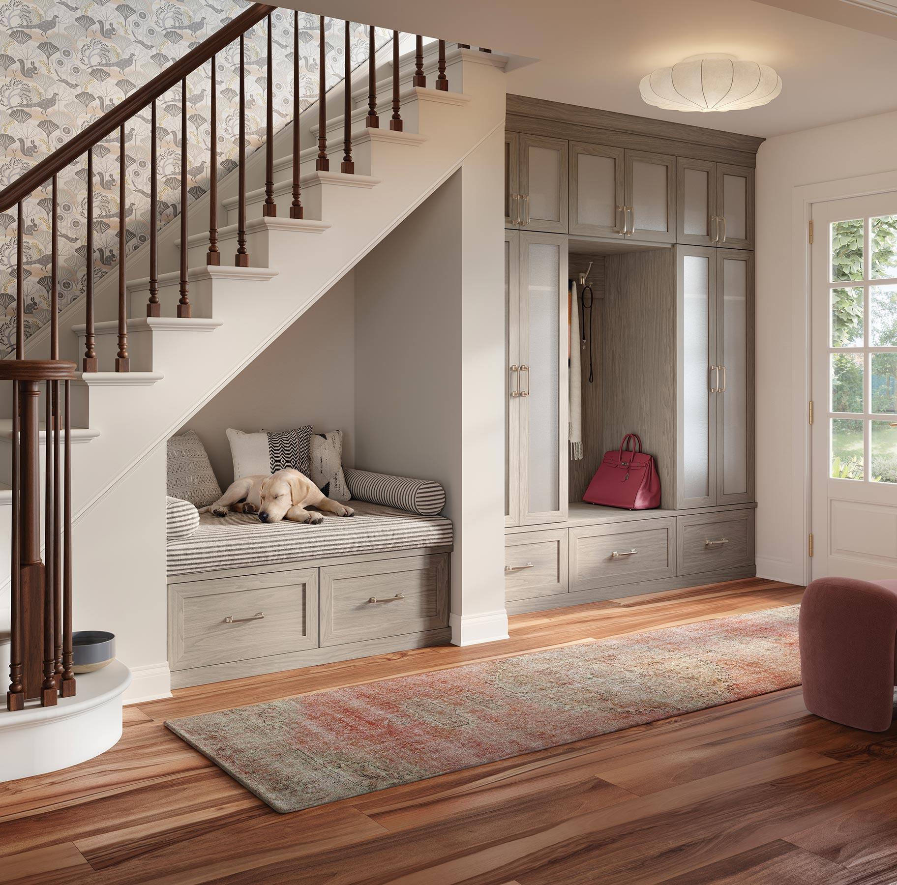 Entrada de lujo con armario de almacenamiento personalizado y banco en acabado de veta de madera gris claro California Closets