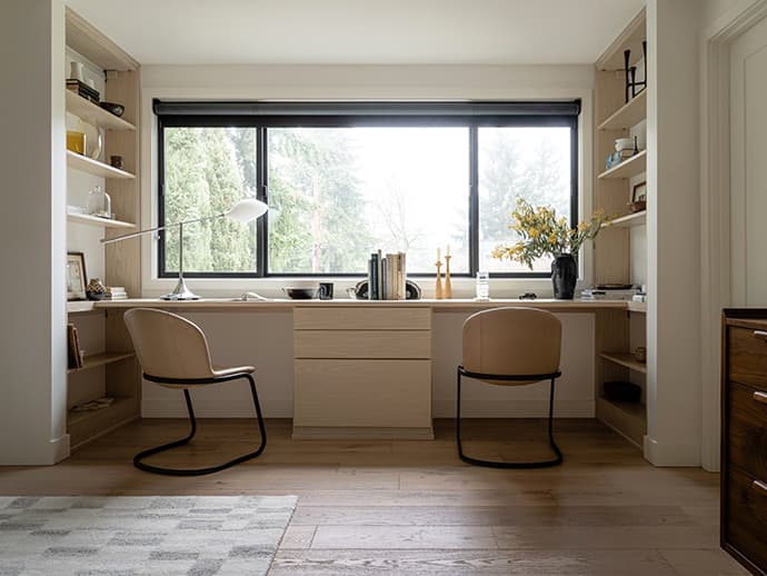 Espacios de coworking con escritorios empotrados, cajones y estanterías de almacenamiento en acabado claro por California Closets