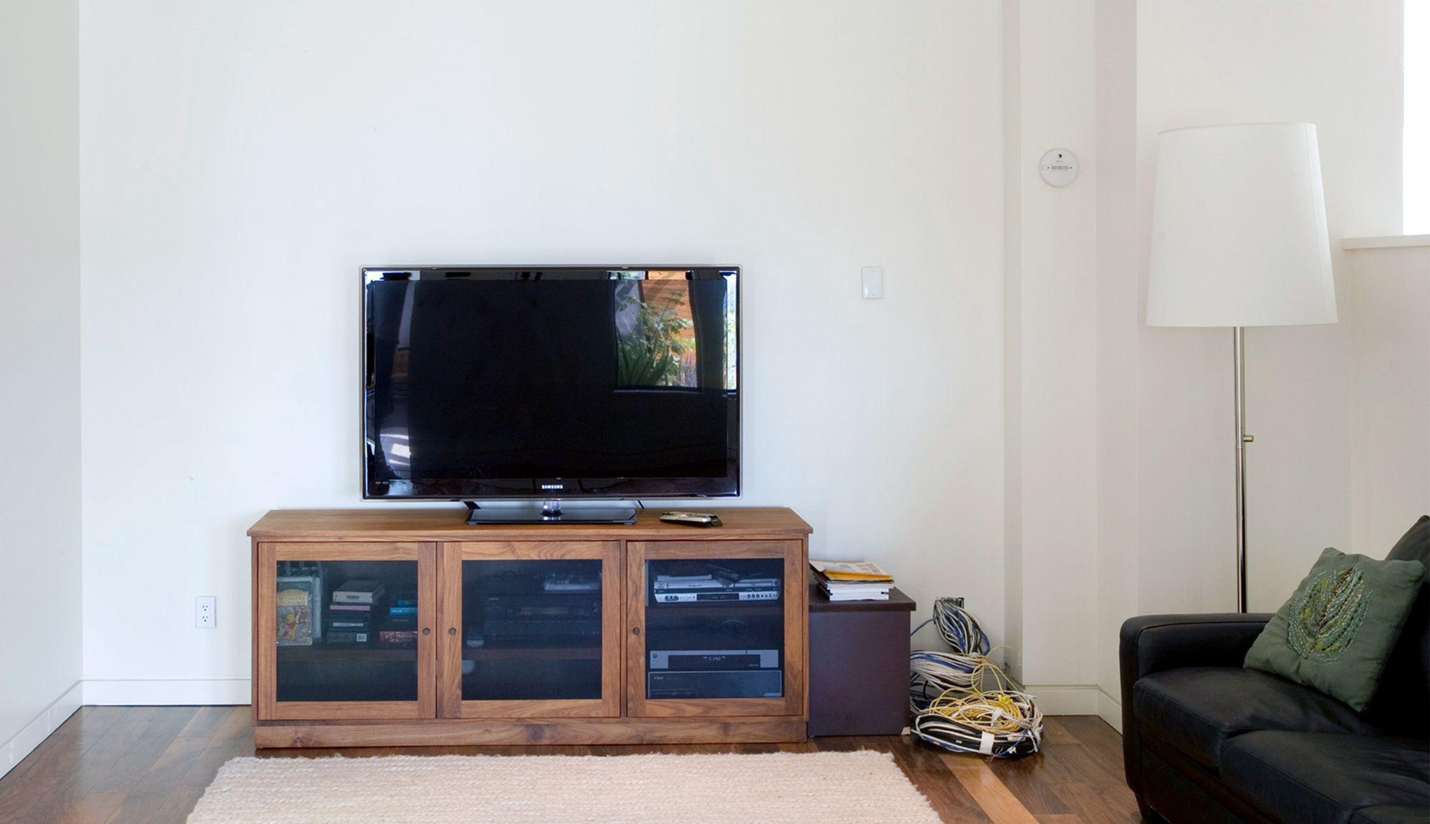 Entertainment lounge with custom media center and storage cabinetry by California closets