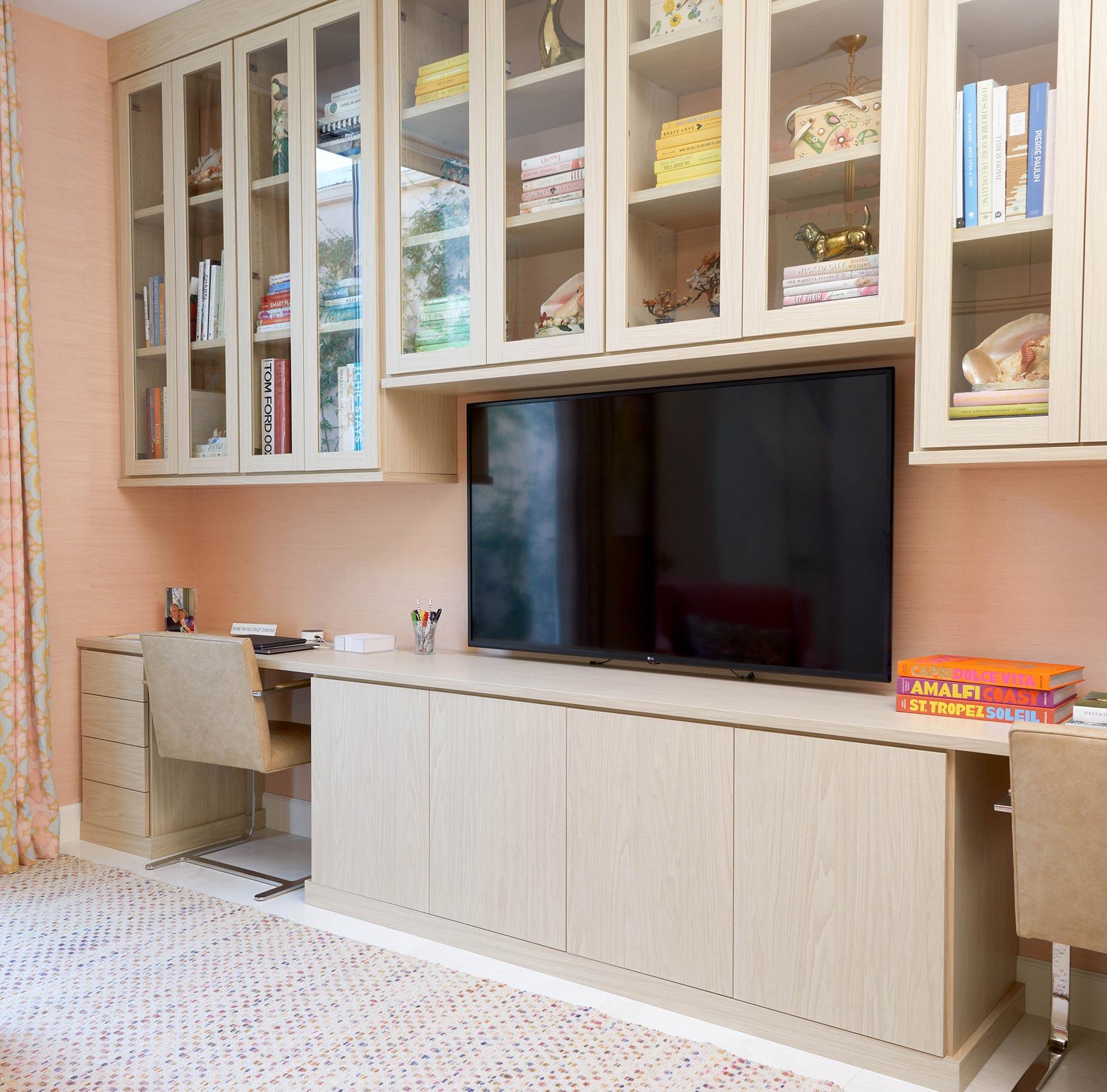 Double desk design in light wood grain finish with shelving and glass cabinet doors from California Closets