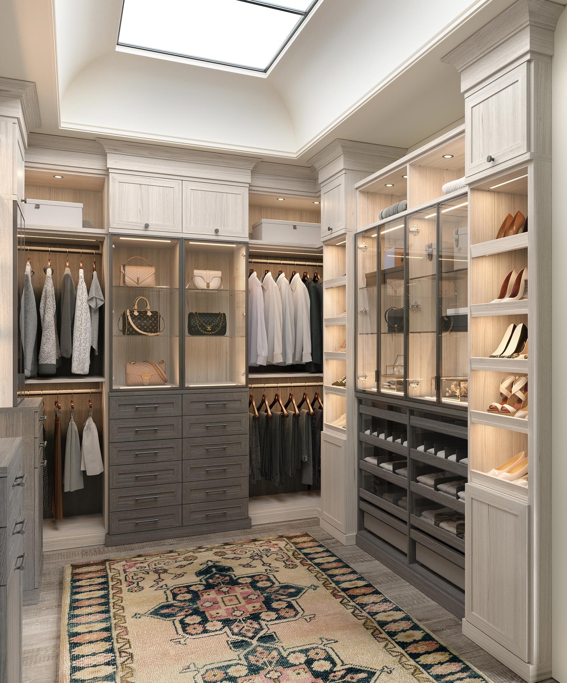 U-shaped walk-in closet designed with wrap around cabinets and glass doors from California Closets