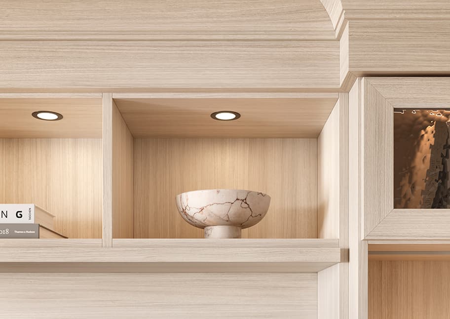 Armario de lujo personalizado en acabado de madera clara con herrajes ocultos y estanterías refinadas, diseñado por California Closets.