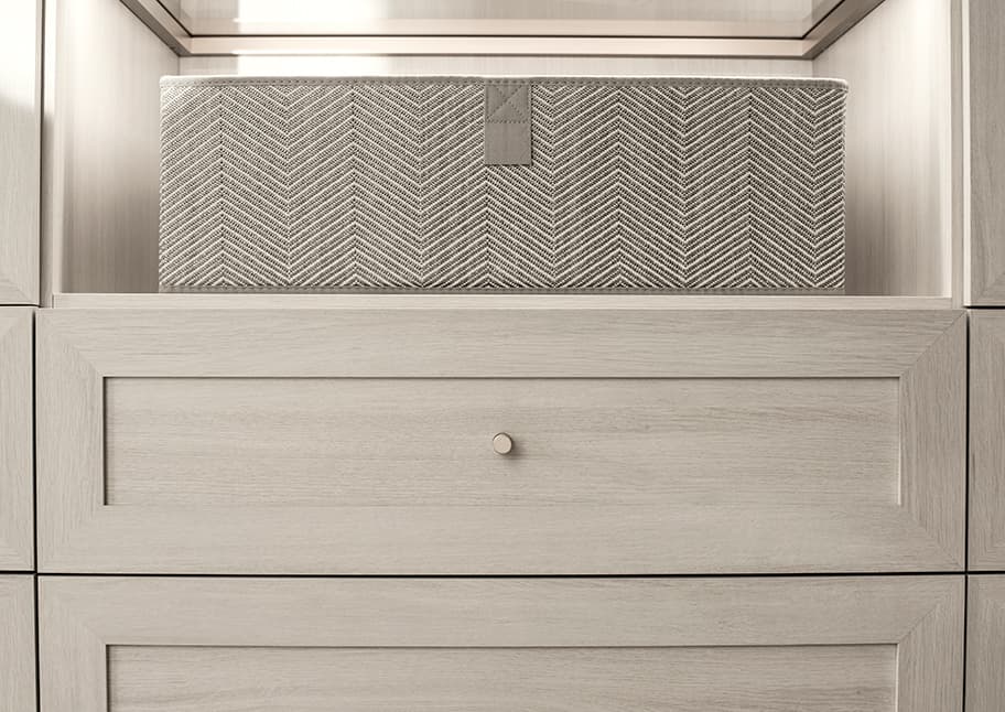 Cajón personalizado en acabado gris claro con detalles de herrajes premium para interiores modernos de lujo, diseñado por California Closets
