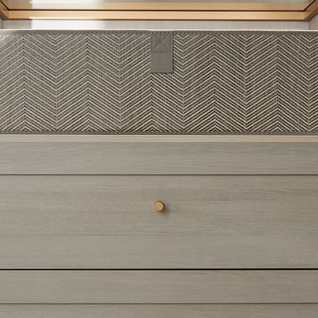 Cajones personalizados con tiradores dorados decorativos en acabado oscuro con encimera de acabado claro de California Closets